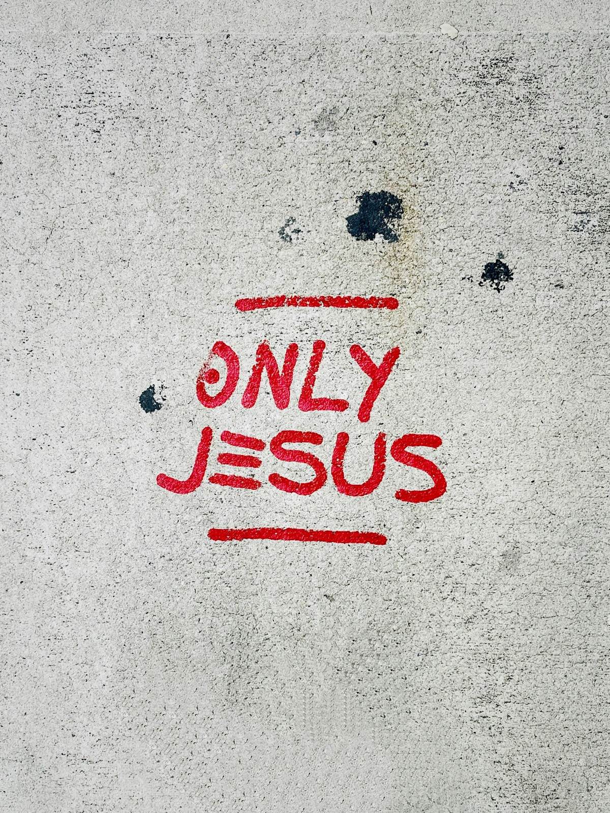 Only Jesus painted on a concrete sidewalk