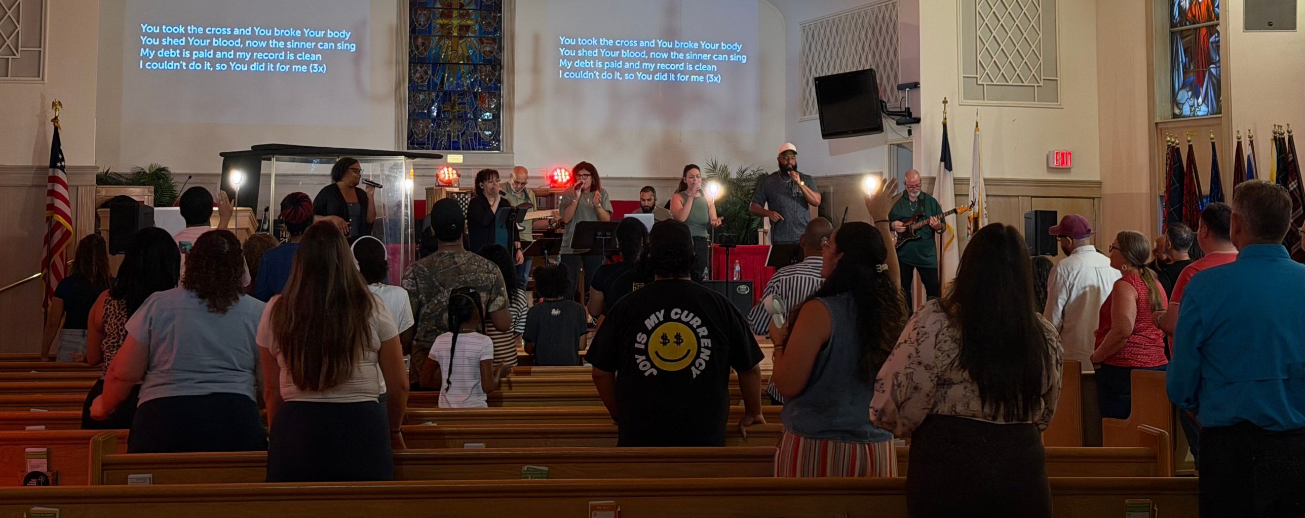 A full room standing in worship as the band leads on a Saturday night at Cruciform