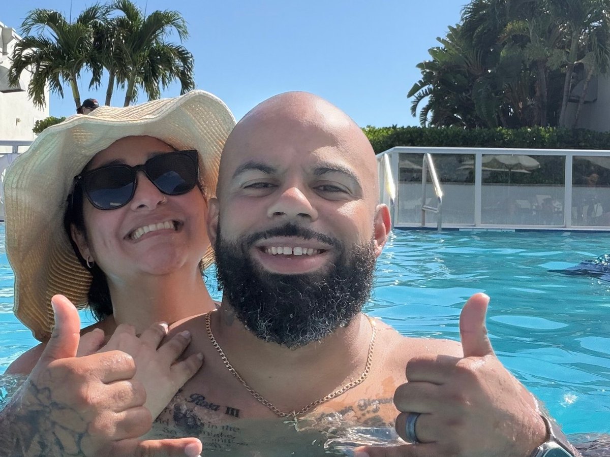 David and Ruth smiling in the pool, throwing shakas