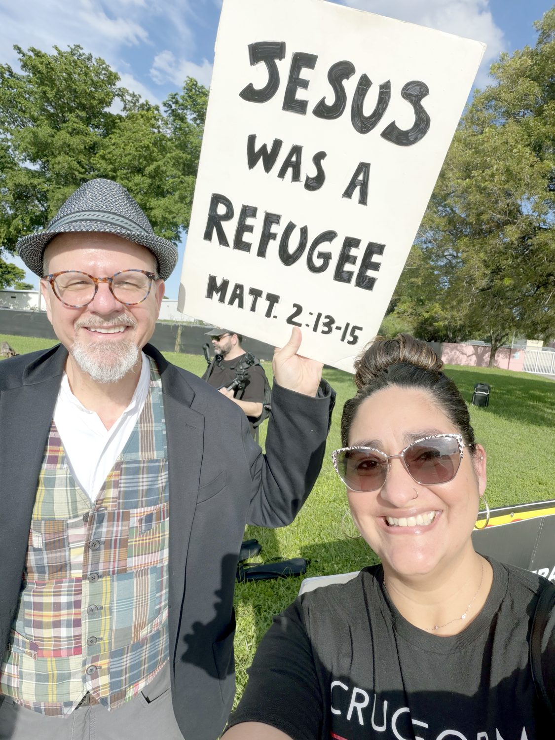 Two Cruciform members at the vigil outside the Broward Transitional Center, holding a sign that reads Jesus Was a Refugee, Matthew 2:13-15